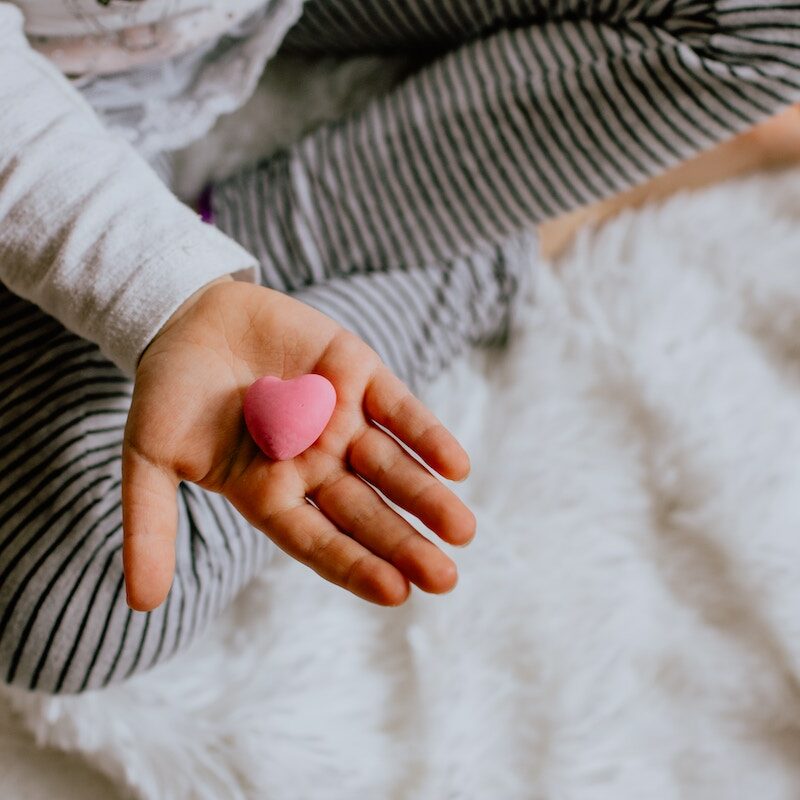 Ladybug Counseling Approach_Image of a child holding a small pink heart